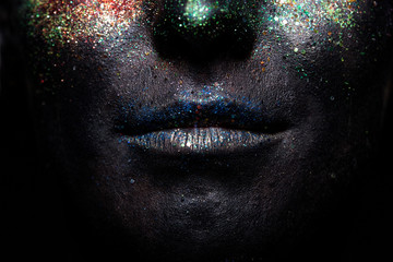 Portrait of beautiful woman with sparkles on her face. Fashion model with colorful make-up