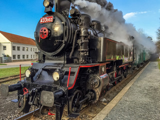 Fototapeta na wymiar Old steam train on rail with nice smoke behind