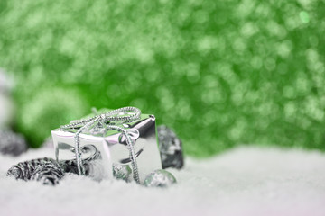 Geschenk auf Schnee vor grünem Hintergrund
