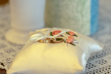Wedding rings lie on a beautifully prepared pillow for the wedding ceremony. Concept: wedding and wedding ceremony