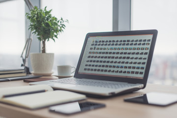Workplace with notebook laptop Comfortable work table in office windows and city view.