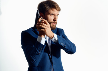 Gangster in a suit holds a gun in his hand