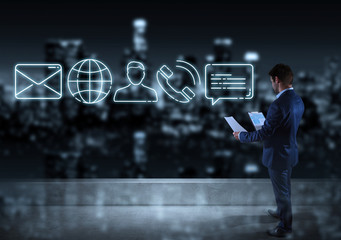 Businessman watching contact icon on the top of a building