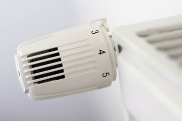 Heat controller knob on radiator  close up macro shot  on white background.