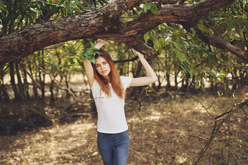 woman stands near green tree in nature