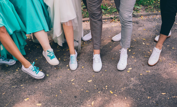 Hipster human legs wearing white sneakers. Wedding in sneakers, love. Soft focus tehnic, wedding dress code