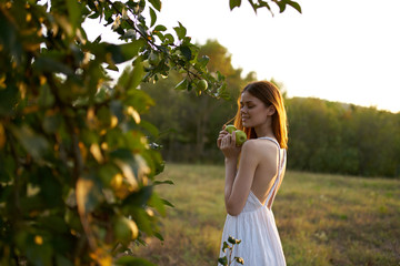 woman in bright clothes holding apples