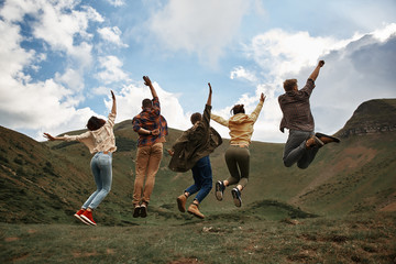 Lets jump. Excited young hikers having fun and jumping while being in the mountains