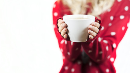 Tender beautiful girl holding a mug of tea in a Christmas sweater in her hands on a white background