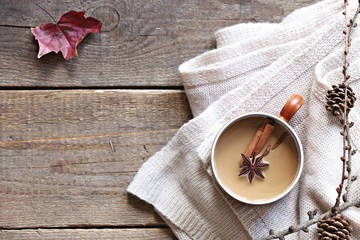 Coffee or tea with milk and spices. Rustic autumn background. Overhead view, copy space