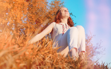 A girl on a walk in a park. Young red-haired girl in the spring 