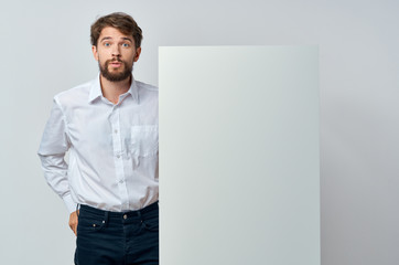 man with a white sheet of paper on a gray background