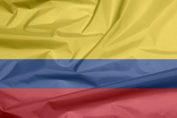 Fabric flag of Colombia. Crease of Colombian flag background, a horizontal tricolor of yellow (double-width), blue and red.
