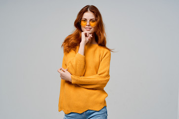 beautiful woman in a yellow sweater on a gray background