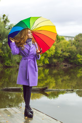 Attractive young casual girl walking in the park with umbrella, autumn day. Weather and people concept - nice lady with umbrella on nature. England rain  