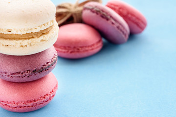 French Macarons on a blue background. Trendy dessert. Sweet cakes.