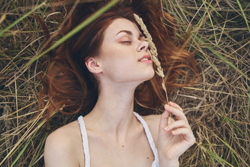 woman lying on the ground in nature dry grass