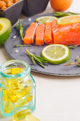 Fish oil capsules and food Omega 3 sources - fish, avocado, nuts, linen seeds, egg