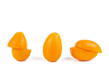 Whole and sliced kumquat fruits isolated on white background