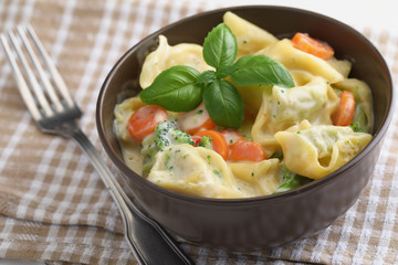 Tortellini with vegetables under cream sauce
