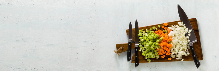 banner of a set of knives on a wooden cutting board and chopped vegetables
