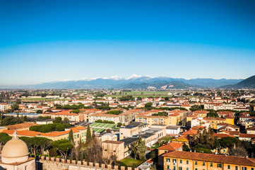 Fototapeta na wymiar Spectacular view on the Pisa city from the height with mountain peaks and snow on the background
