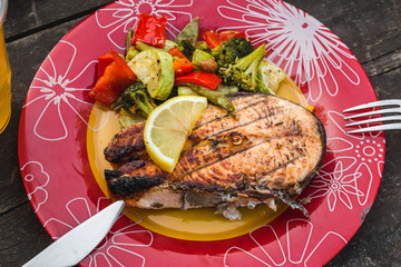 Grilled salmon steak with vegetables on plate