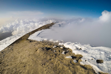 Cratere dell'Etna tra le nuvole e neve e vapore © Etna ·REC Attivo
