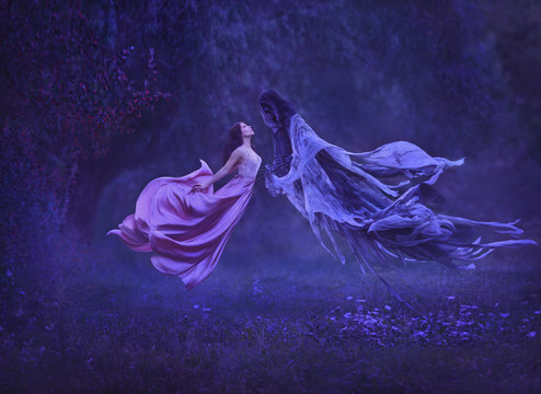 The mysterious witch is dancing with a demon, dark forces, in the air. Kiss dementor. Taking away the soul. A dress waving in the wind during the flight. Harry Potter. Art photo of levitation