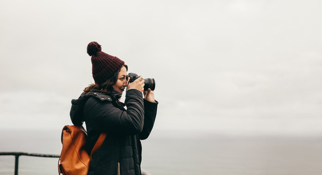 Woman traveler takes pictures of the landscape