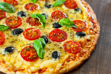 Pizza Margherita or Margarita with Mozzarella cheese, tomato, olive. Italian pizza on wooden background