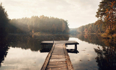 The Breath Of Autumn. Autumn foliage and fog lake in morning with boat dock - Powered by Adobe