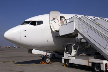 White modern aircraft on the parking zone awaiting service maintenance