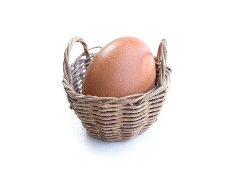 Close up of chicken egg in a basket isolated on white background