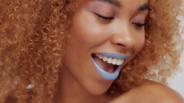 woman with bright blue lips shows tong Closeup video ideal skin texture