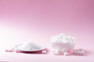 Fototapeta na wymiar Sugar in cubes abd crystaline on pink background