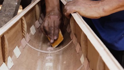 Artisan Sanding the Wood. Manufacture of a Musical Instrument.
