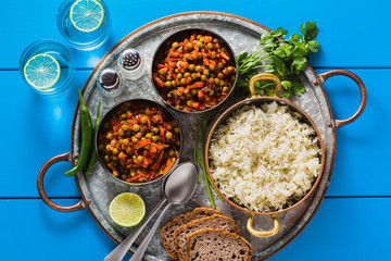 vegan curry with green peas and basmati rice served on a blue table tray, healthy Indian comfort food and lemonade in glasses