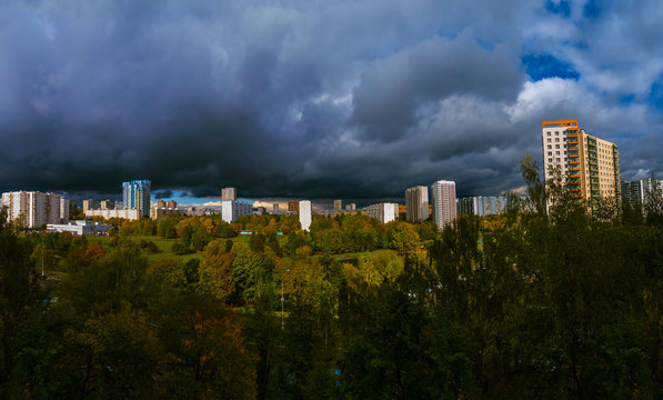 Panorama residential disctrict of Moscow at autumn with dark beautiful rainy clouds in the blue sky, soviet buildings, a large park &ndash; panoramic view of the city in high resolution