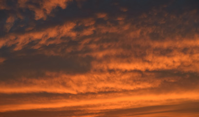 Dramatic sunset sky with orange colored clouds.
