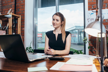 Business woman working at the office looking at camera.