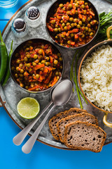 vegan curry with green peas and basmati rice served on a blue table tray, healthy Indian comfort food