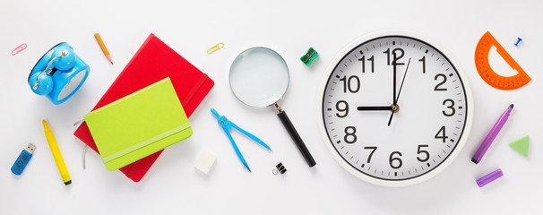 school accessories and wall clock at white background