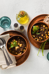 Moroccan black lentil soup with chickpeas and cauliflower in bowls on the table. healthy vegan comfort food with whole wheat bread