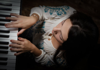 Beautiful girl and piano keyboard.