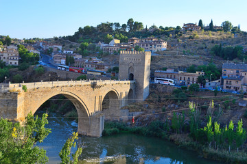 Toledo, Spain - September 24, 2018: People performing extreme sport of Zip Line with the San Martin Bridge in the background in Toledo.