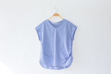 Natural colour blue clothes is clothes hanger on white background.