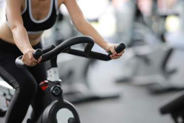 Close-up footage of a women working out in gym on the exercise bike, young woman cycling in the gym. female exercising in fitness gym for good health.
