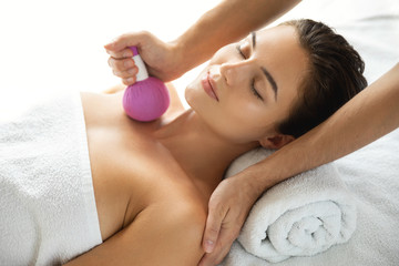 Obraz na płótnie Canvas Woman is enjoying Asian massage therapy with herbal compress