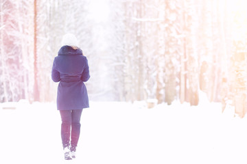 A young girl in a winter park on a walk. Christmas holidays in t